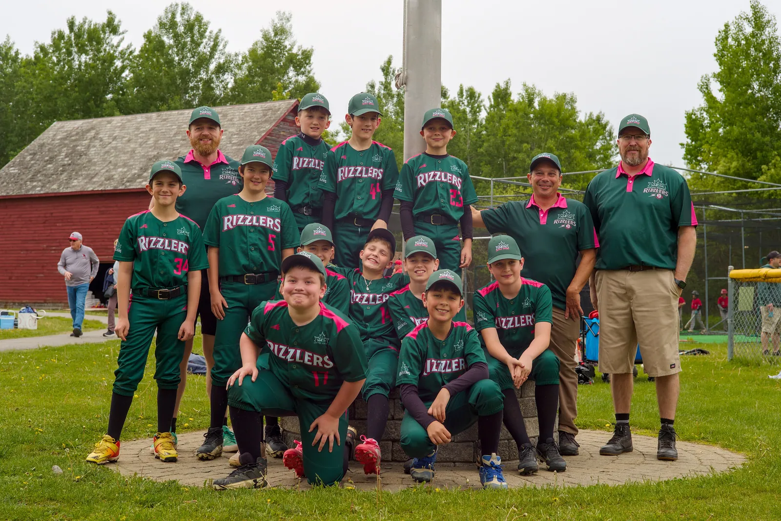 The Rizzlers team and coaches in front of a red barn