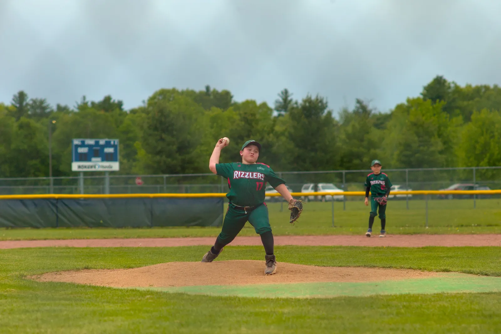 A Rizzlers pitcher throws on a cloudy day