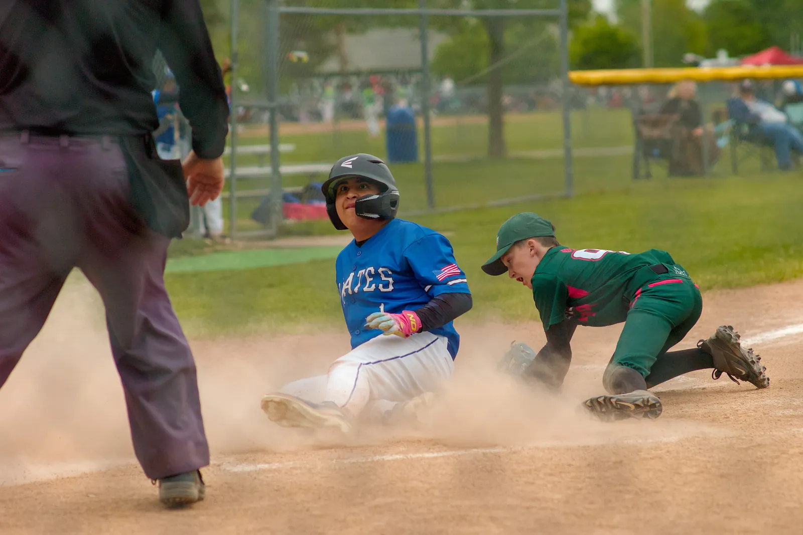 A Rizzlers player tags a runner sliding into base