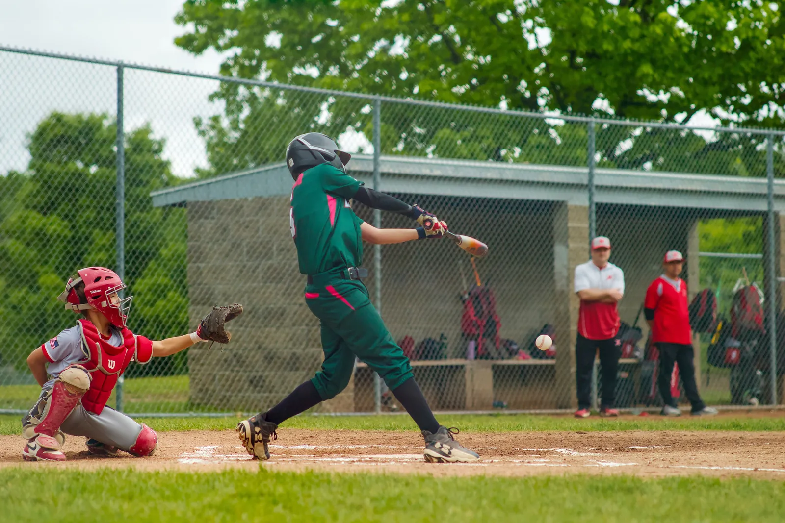 A Rizzlers batter swings in front of the dugout