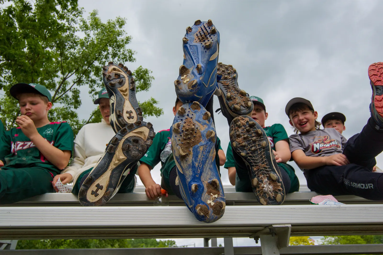 Rizzlers players show off their cleats on the bench