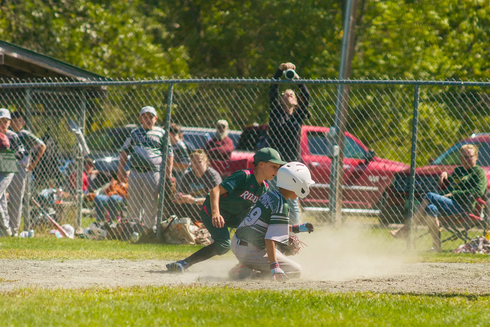 A runner slides into home in a cloud of dust