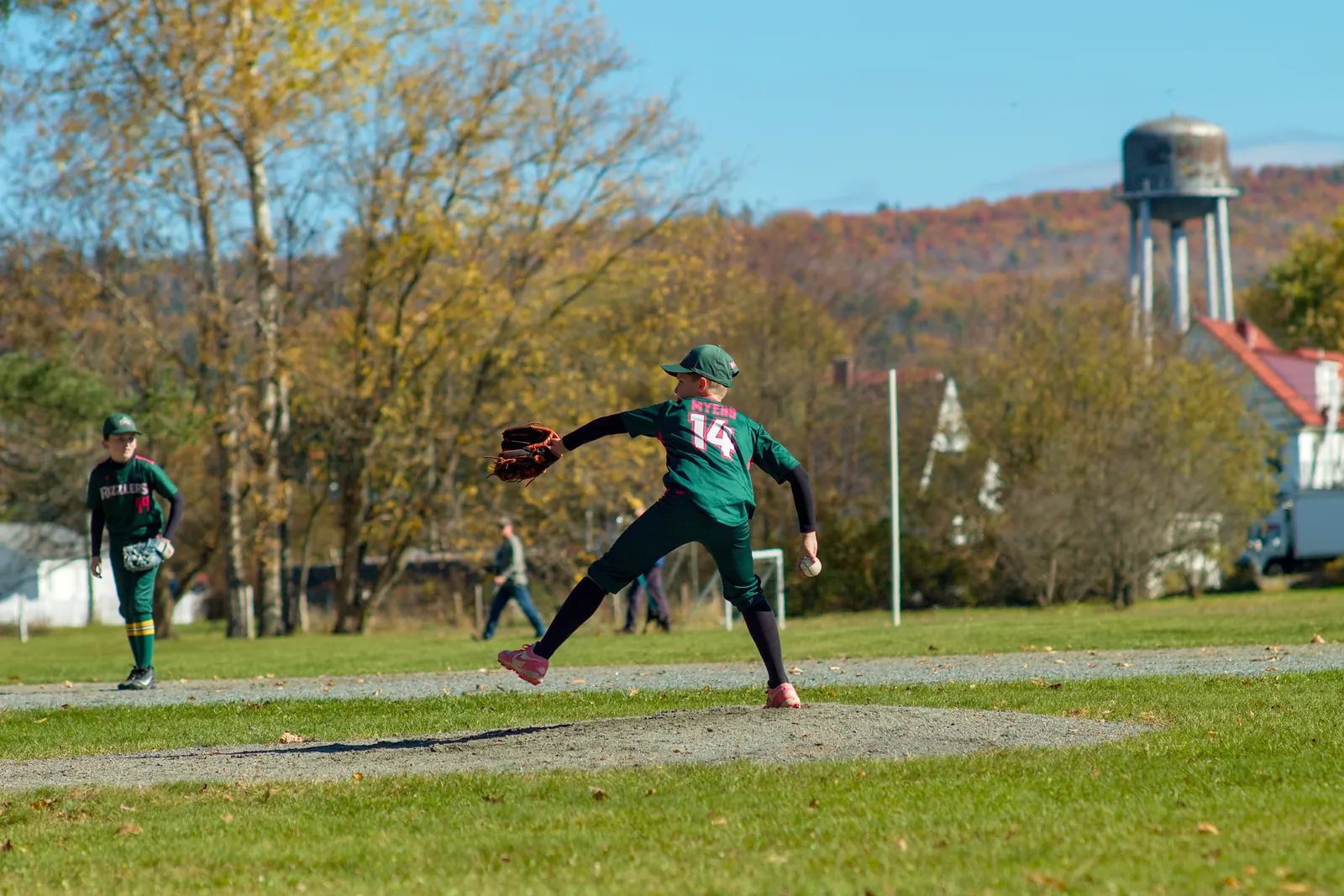 A Rizzlers pitcher throws with a water tower behind